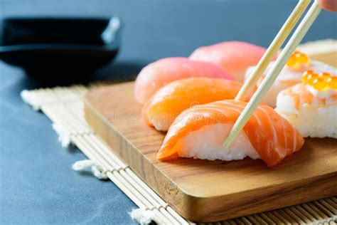 Salmon Sushi Nigiri In Chopsticks Stock Photo Image Of Fillet