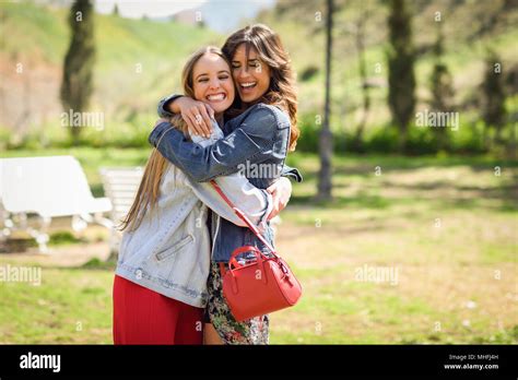 Two Happy Girls Hugging In Urban Park Blonde And Brunette Girls
