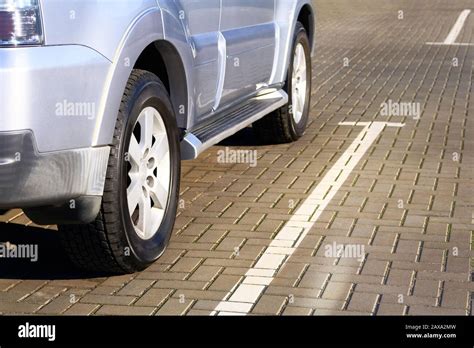 Silver Car Is Parked In Its Parking Spot In City Close Up Car Wheel