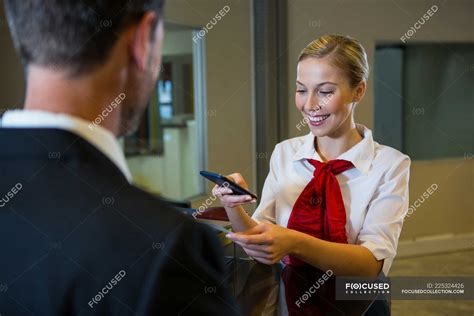 Female Scanning The Boarding Pass With Mobile Phone At Airport Terminal — Businessman Woman