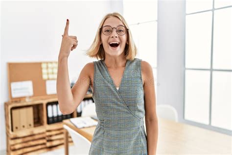 Young Caucasian Woman Working At The Office Wearing Glasses Pointing Finger Up With Successful