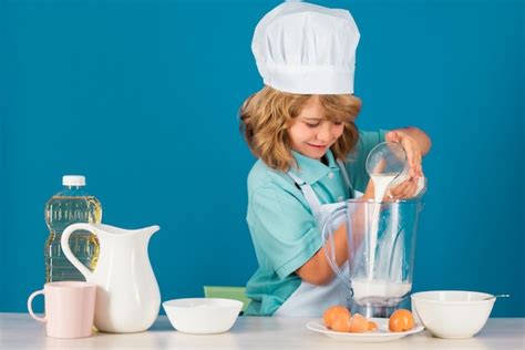 Niño chico con sombrero de chef y delantal cocinando preparando comida