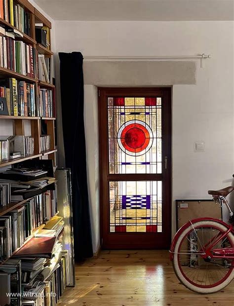 A Bicycle Is Parked In Front Of A Bookcase With Stained Glass Window