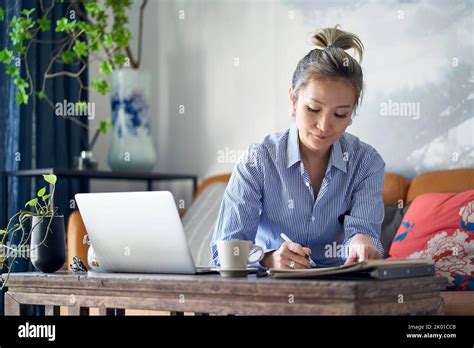 Mature Professional Asian Woman Working From Home Taking Notes While
