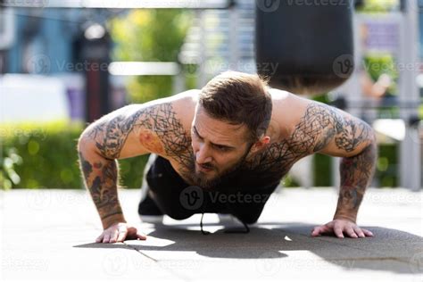 Muscular Bodybuilder Handsome Man With Naked Torso Trains Triceps In A