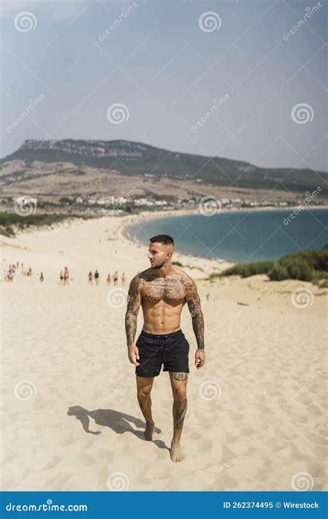Handsome Half Naked Caucasian Man Walking On The Sand Enjoying His