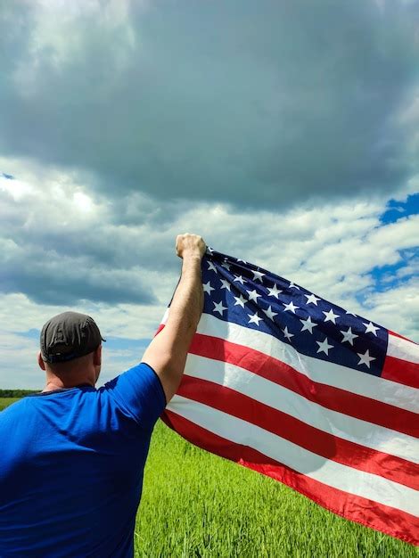 Um homem segura uma bandeira dos eua na mão Foto Premium