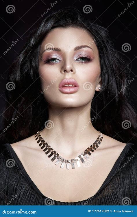 Portrait Of A Brunette Woman With A Chic Hairstyle And A Necklace