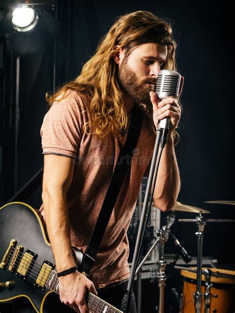 Hombre Joven Que Canta Y Que Toca La Guitarra El Ctrica En Etapa Imagen