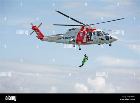 Search and rescue SAR helicopter crew lowers sea rescue swimmer Stock Photo - Alamy