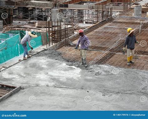 Construction Workers Leveling Wet Concrete Has Been Poured Editorial