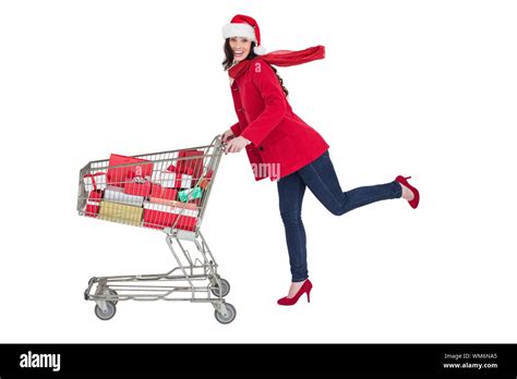 Festive Brunette Pushing Trolley Full Of Gifts On White Background