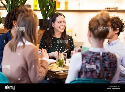 happy friends eating at bar or restaurant Stock Photo - Alamy