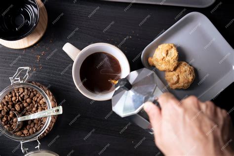 Premium Photo Top View Barista Pouring Coffee From Moka Pot Coffee Maker To A Coffee Cup Hand