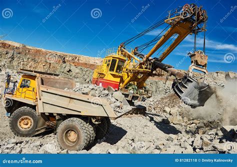 Excavator Loading Granite Or Ore Into Dump Truck At Opencast Stock