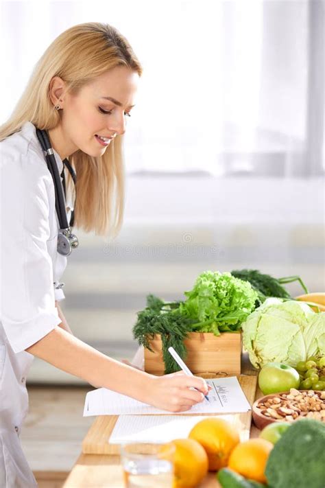 Nutritionist Writing Healthy Diet Plan For Patient With Healthy Fruit