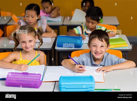 Cute Classmates Smiling In Classroom Stock Photo Alamy