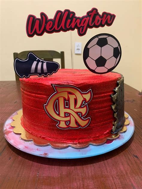 A Red Cake Sitting On Top Of A Wooden Table Next To A Sign That Says