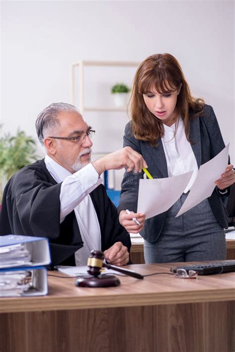 Old Male Judge And His Young Secretary In The Office Stock Photo