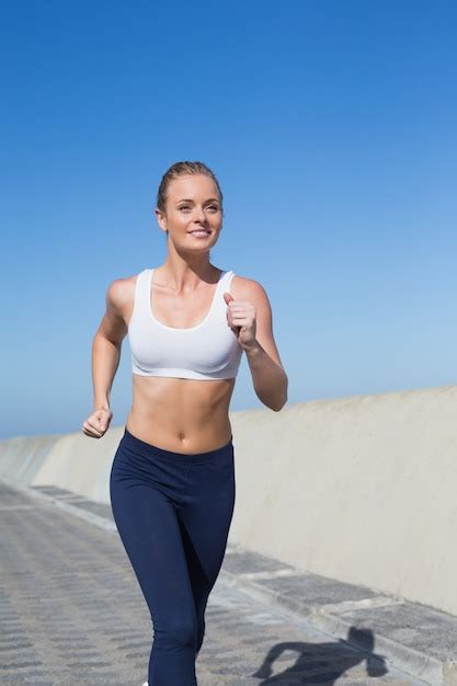 Premium Photo Fit Blonde Jogging On The Pier