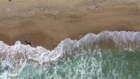 Slow Motion Aerial View Of Ocean Waves Washing A Secluded Sandy