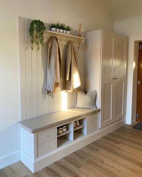 A Room With White Walls And Wooden Flooring Two Coats Hanging On The Wall