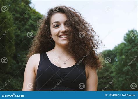Glückliche Jugendliche Mit Dem Langen Gelockten Haar Des Brunette in