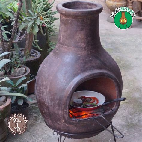 A Large Clay Pot Sitting On Top Of A Metal Stand Next To Pots And Plants