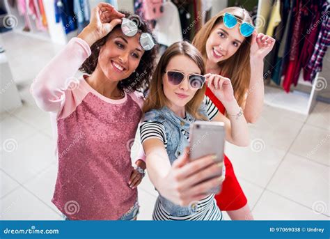 Les Amies De Sourire Utilisant Les Lunettes De Soleil élégantes Ayant L