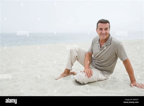 Portrait Of A Mature Man Sitting On The Beach And Smiling Stock Photo Alamy