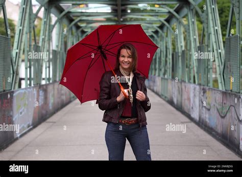 Beautiful Brunette Woman With Red Umbrella Standing On A Bridge With Graffiti Stock Photo Alamy