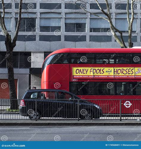 Red Bus And Black Taxi On A Background Of A Gray Building Editorial