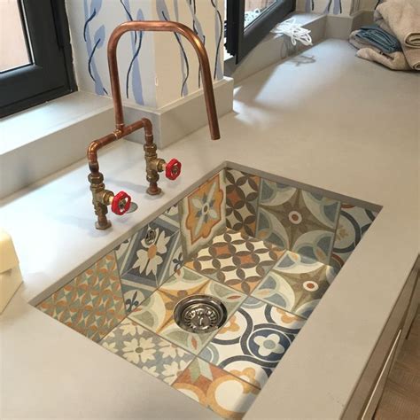 A Sink In A Bathroom With Colorful Tiles On The Floor And Walls Behind