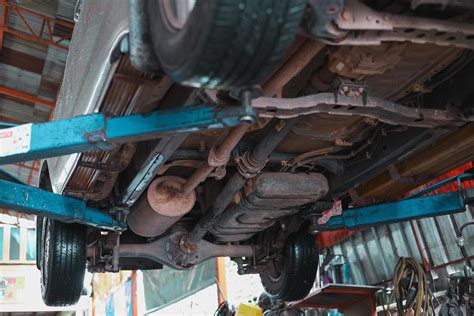 The Undercarriage Of A Car With A Jack Is Lifted For Repairs