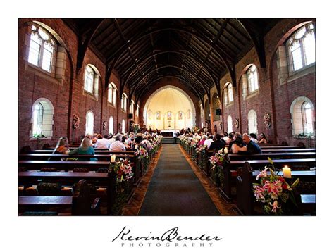 people are sitting in pews at the end of a church with stained glass windows