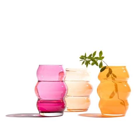 Three Different Colored Vases Sitting Next To Each Other