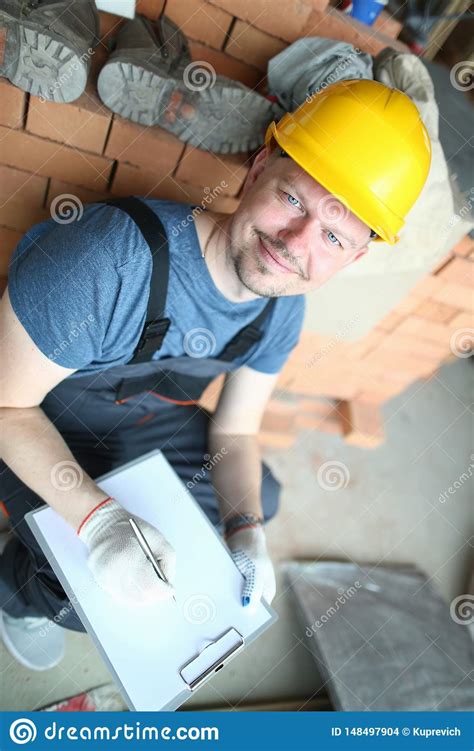 Construtor Masculino Em Posses Amarelas Do Capacete De Seguran A Foto