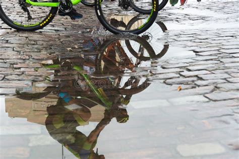 Reflection Of Cyclists In The Puddle Of Water During Warm Up For A Race