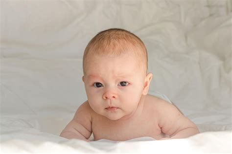 Premium Photo Newborn Baby On White Bed Linen Lying On His Stomach On