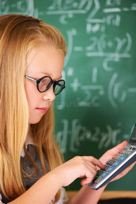 Solving Complex Math Problems A Cute Blonde Girl Using Her Calculator In Class Stock Photo
