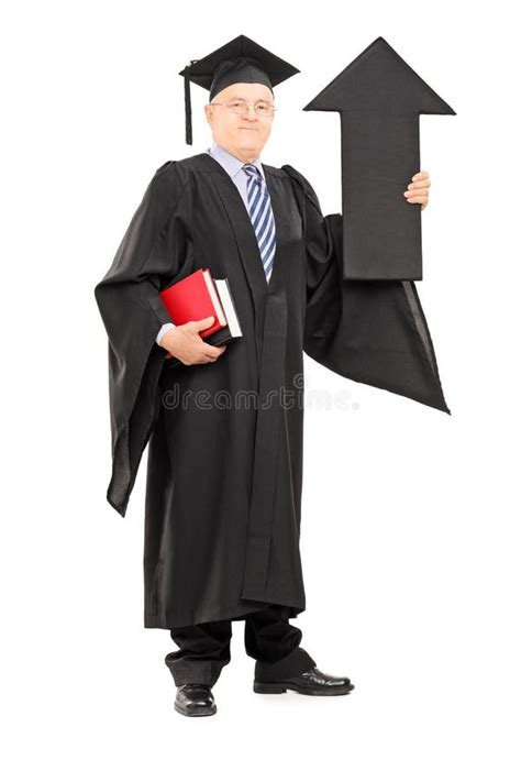 Full Length Portrait Of A Mature Man In Graduation Gown Holding Big