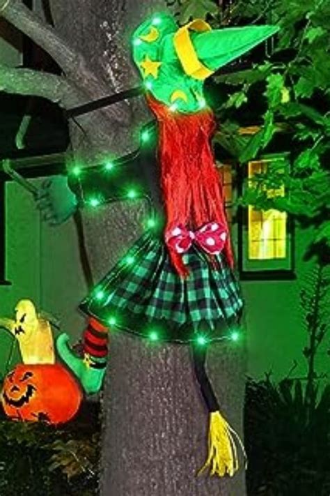 A Lighted Scarecrow Standing Next To A Tree