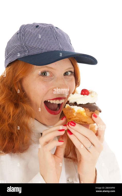 Female Baker Chef With Red Hair Eating Pastry Isolated Over White