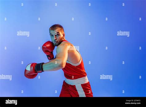 Knockout Punch Male Boxer In Red Uniform And Boxing Gloves Training