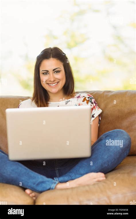 Pretty Brunette Relaxing On Couch With Laptop Stock Photo Alamy
