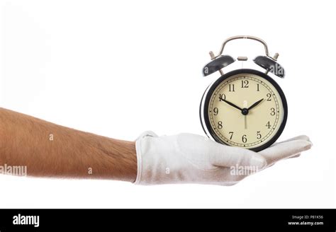 Alarm clock on a gloved male hand isolated on white background ...