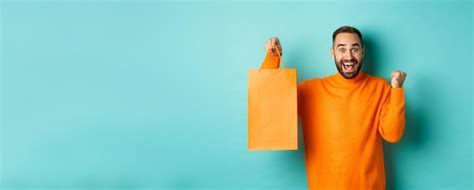 Hombre Feliz Sosteniendo Una Bolsa De Compras Naranja Y Regocij Ndose