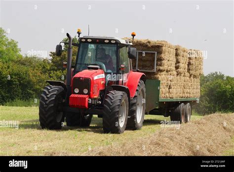 Massey Ferguson 6470t Tractor Hitched To A Twin Axle Bale Trailer Loaded With Pre Bound Large