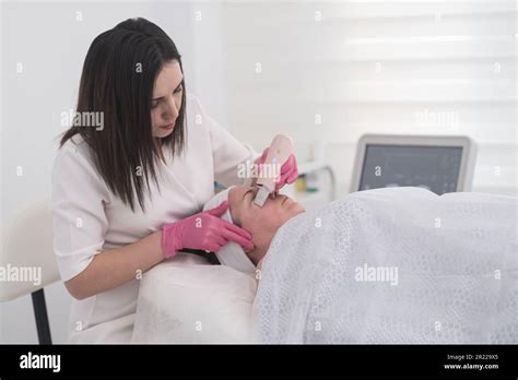 Beautician In Gloves Uses Ultrasonic Spatula For Facial Skin Scrubbing