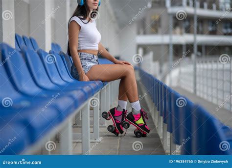 Dark Haired Girl In Roller Skates Sitting And Resting Stock Image